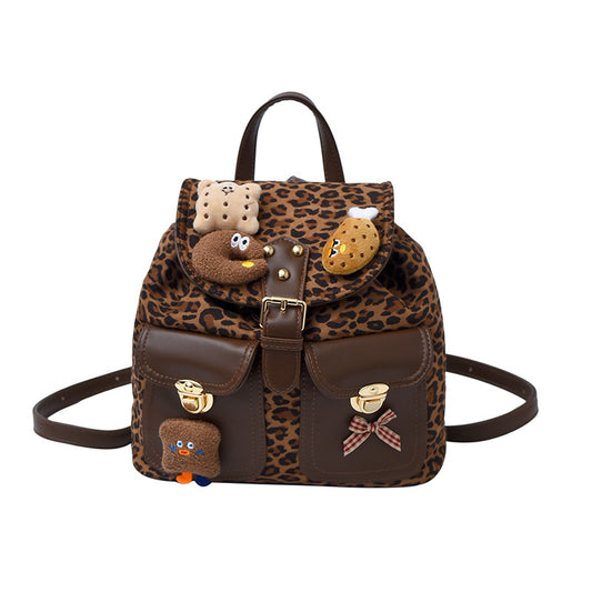 Mini backpack featuring a leopard print design with playful food-themed charms and two front pockets.