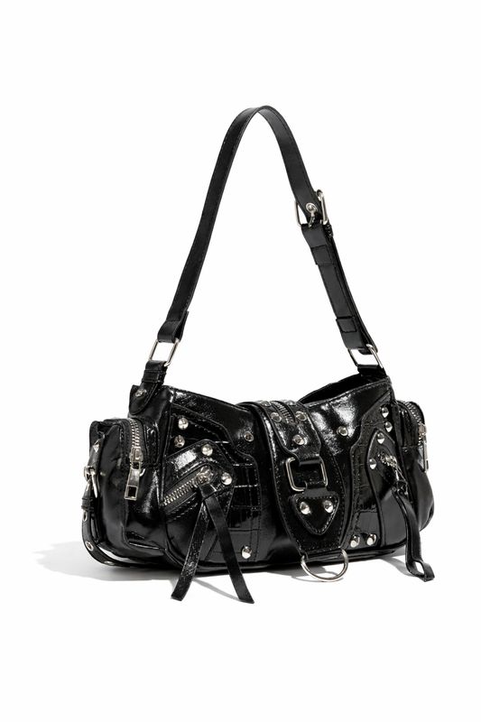Black patent leather crossbody bag featuring studs, zippers, and a stylish adjustable strap. Ideal for edgy fashion.