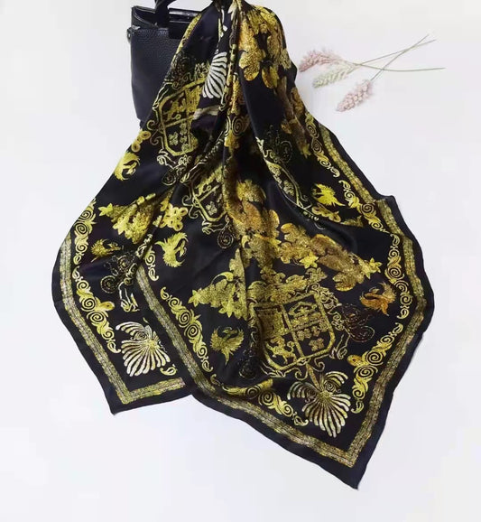AriaLuxe The Mulberry Square Silk Scarf featuring a black background with intricate gold floral and emblem designs.