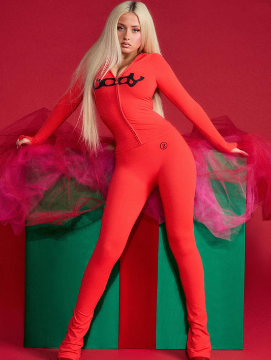 AriaLuxe Body Jumpsuit in vibrant red, featuring a zip front and logo, paired with a pink tulle skirt, set against a festive 