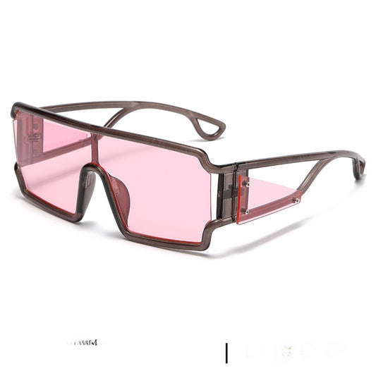 Avant-garde one-piece square sunglasses with a transparent brown frame and pink lenses, featuring a unique geometric design.