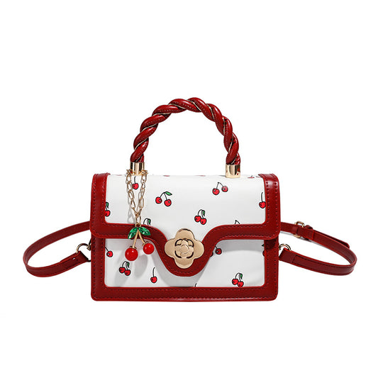 Sweet Cherry Mini Crossbody Bag featuring a white body with cherry print, red accents, and a braided handle.