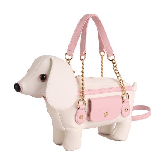 Puppy Love Crossbody in white and pink, shaped like a dog with a chain strap and a small front pocket.